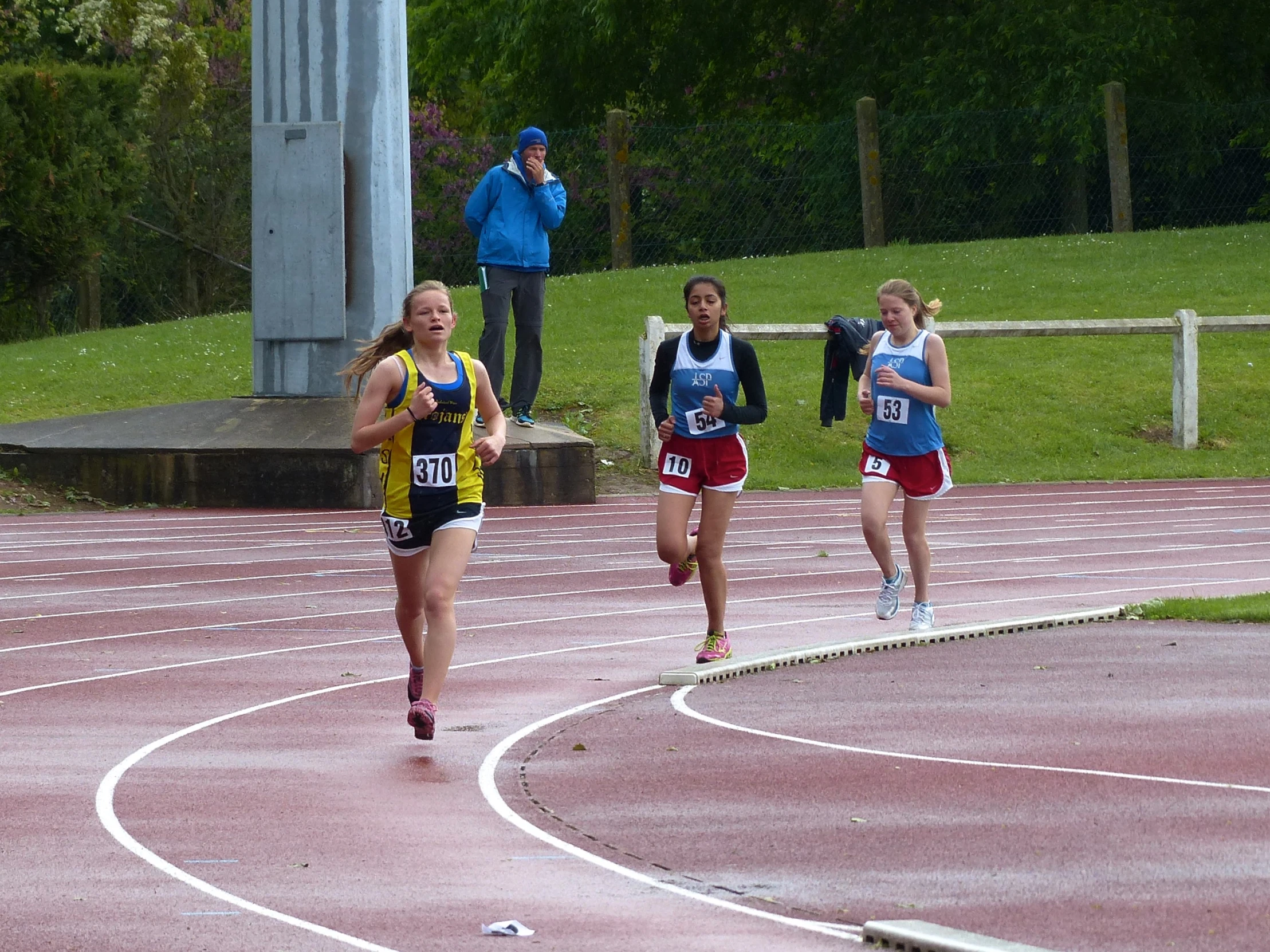 a group of women running down a track