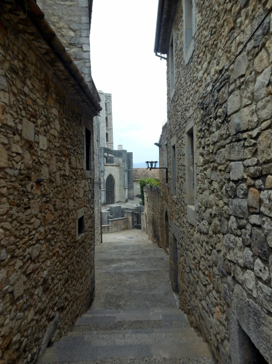 stone buildings line a path between two old buildings
