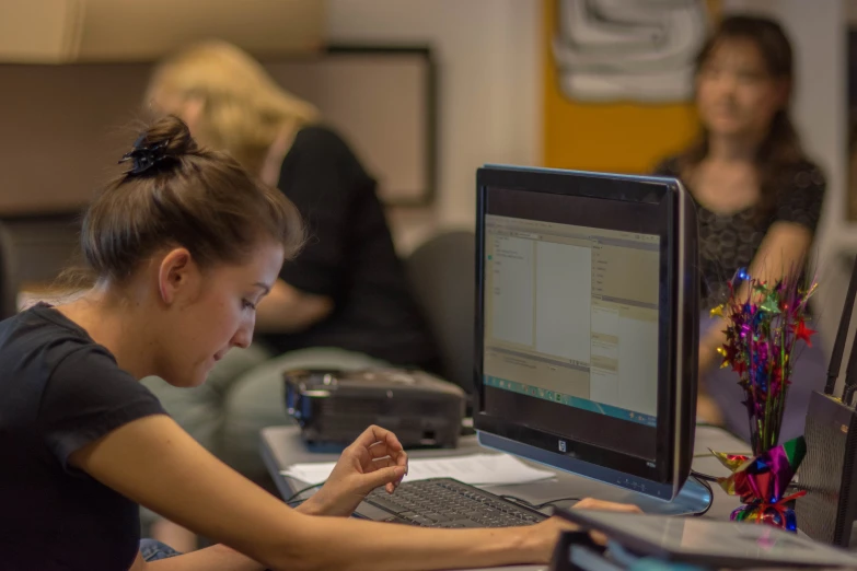 a woman sitting at a table working on a laptop