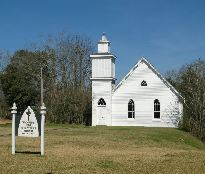 a small white church with a sign outside