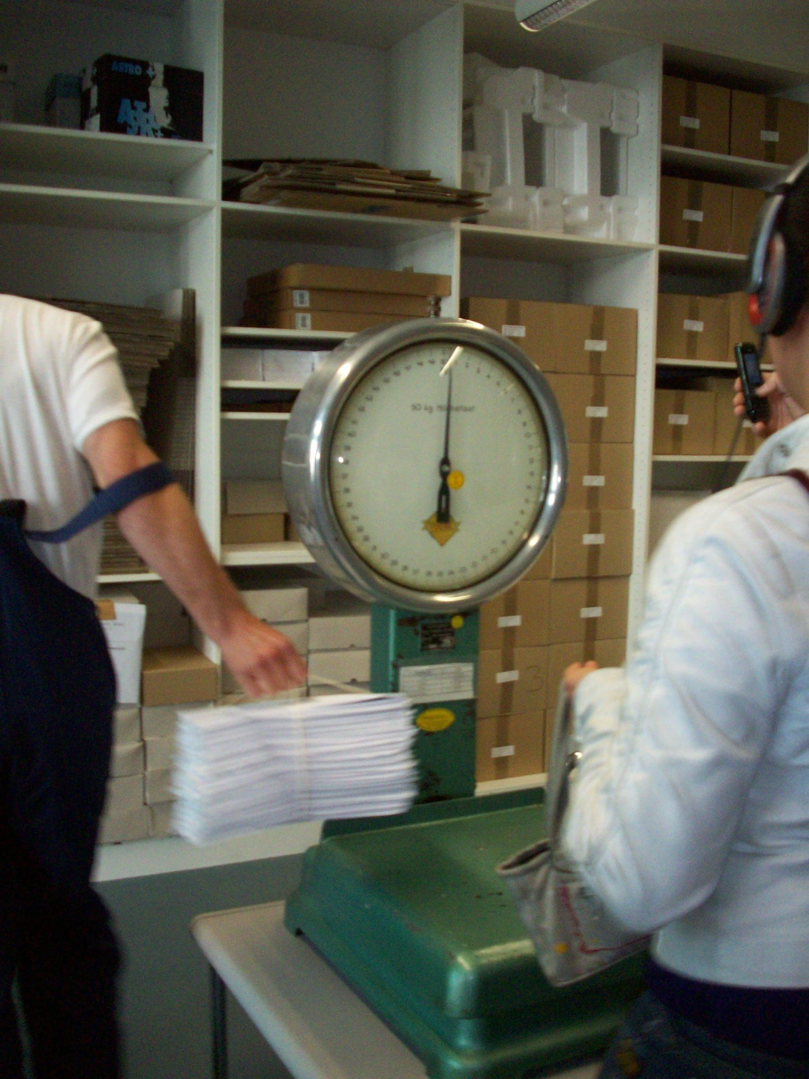 two men in an office setting in front of a dial clock