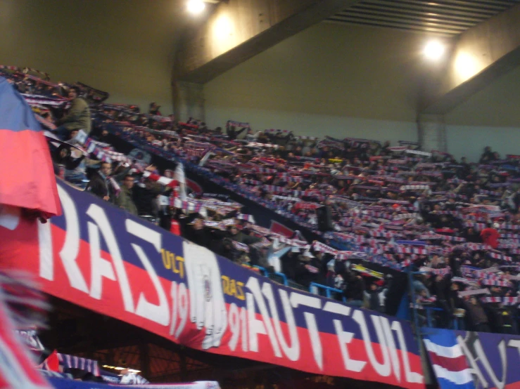 a large crowd is holding signs in the stands