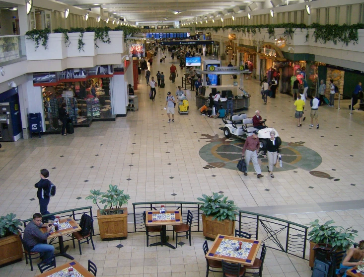 a group of people at tables in an indoor mall