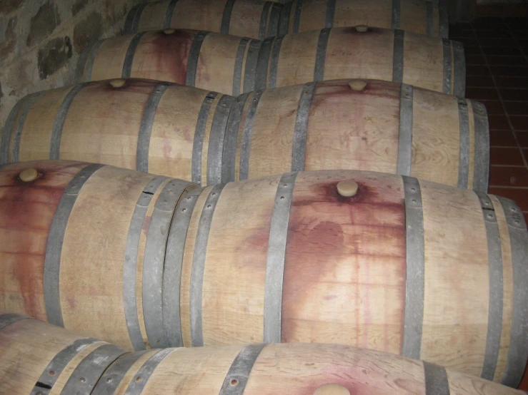 several large barrels stacked in a room with tile floors