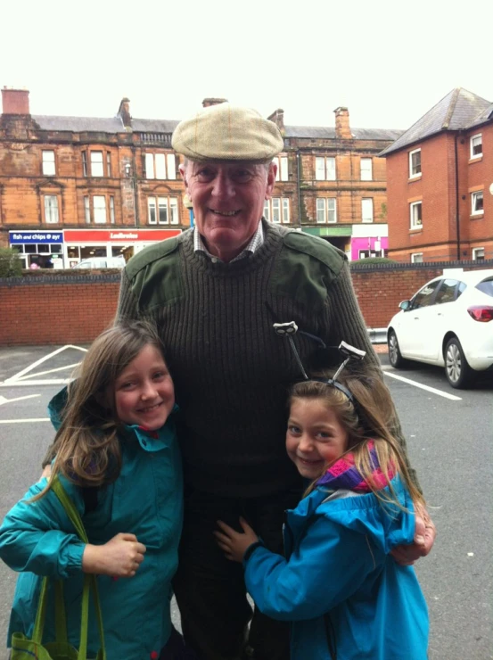 an elderly man posing for the camera with two s