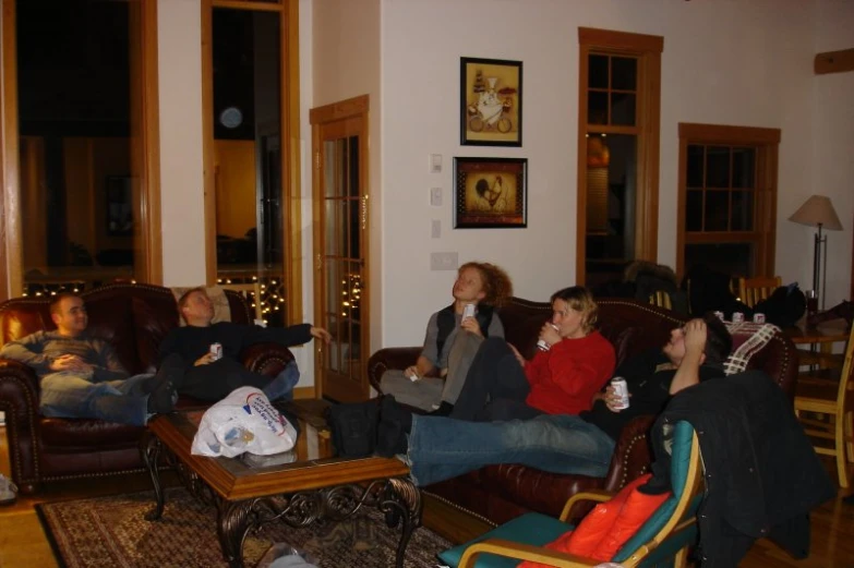several people relax in chairs and lounge around a coffee table