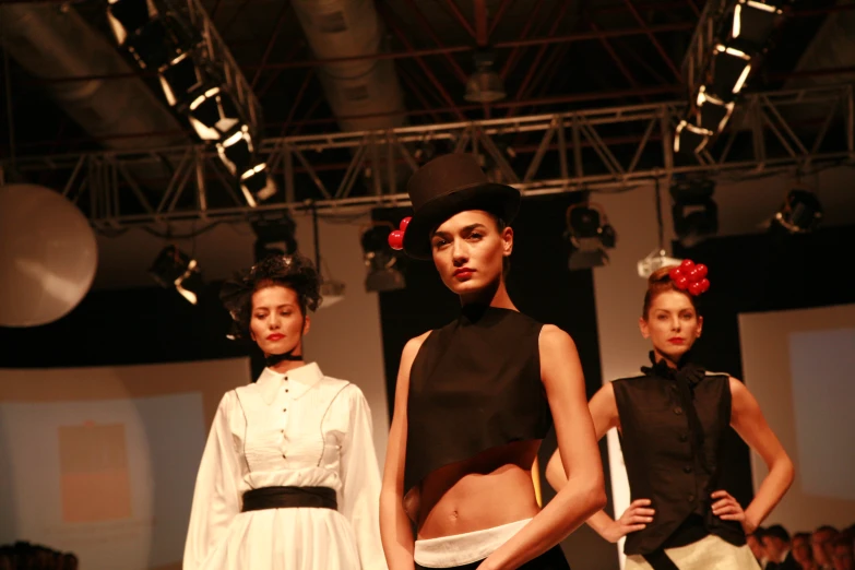 two models wearing black and white dresses and headpieces