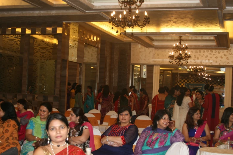 many women are sitting in chairs at a dinner