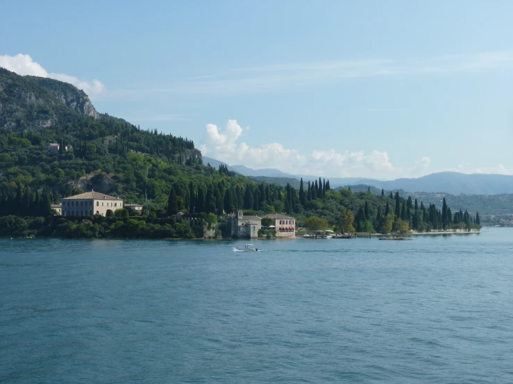 a large body of water next to a lush green hillside