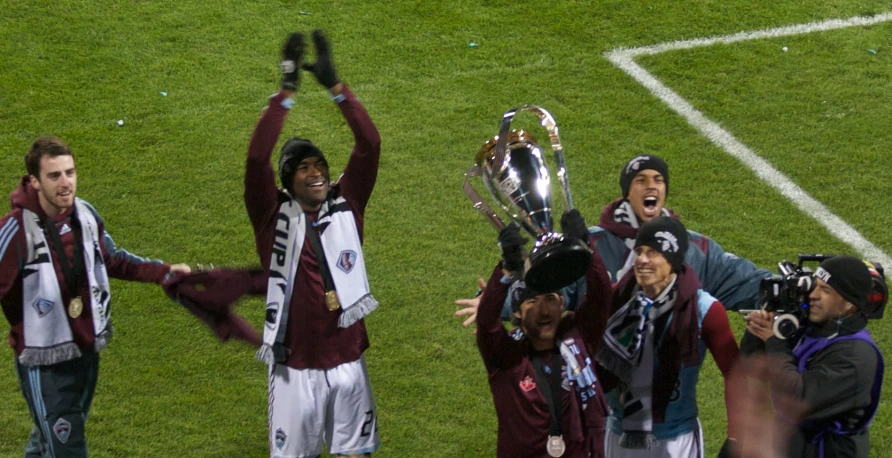 several people on a field with a trophy