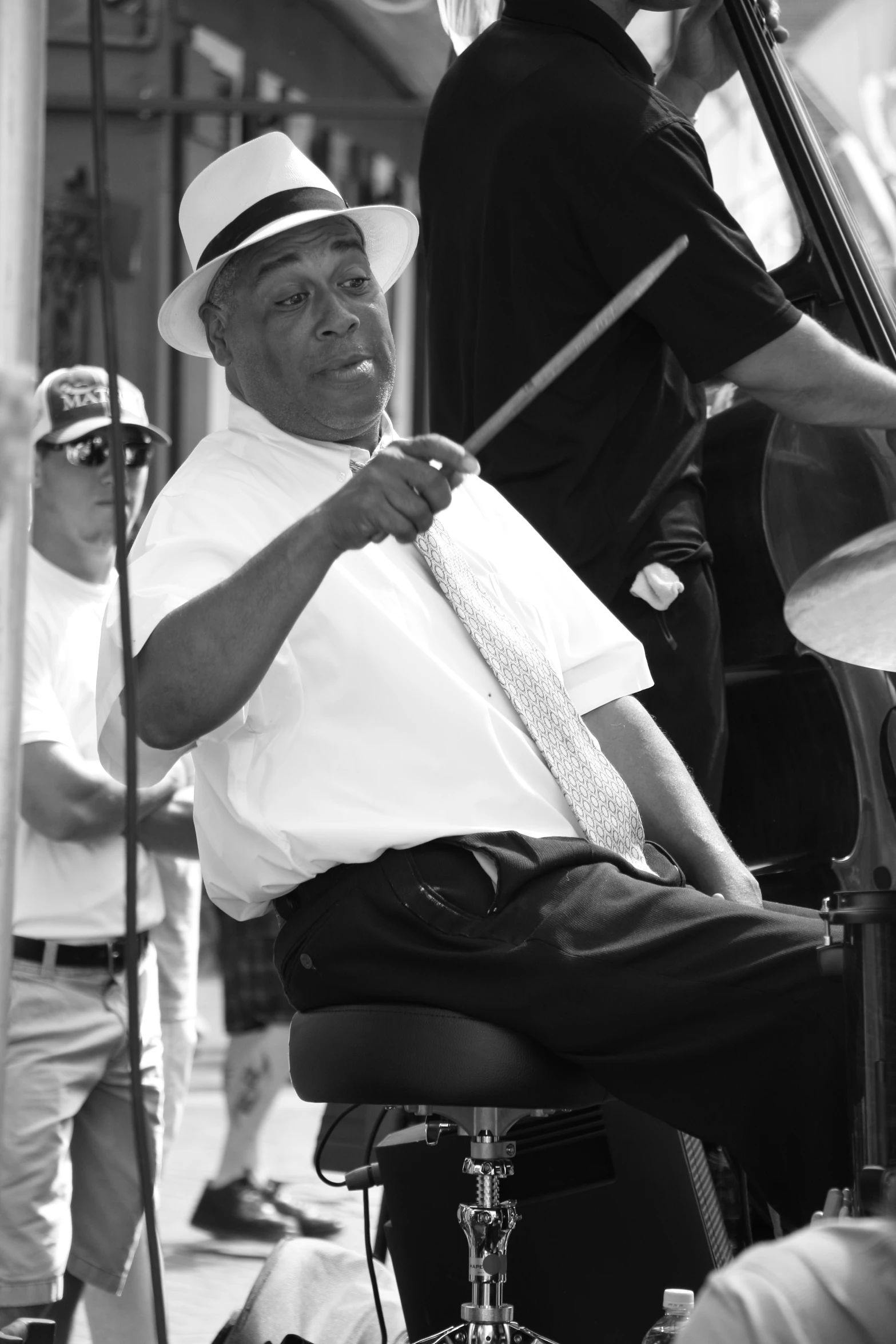 an old man sitting on a chair with his tie over