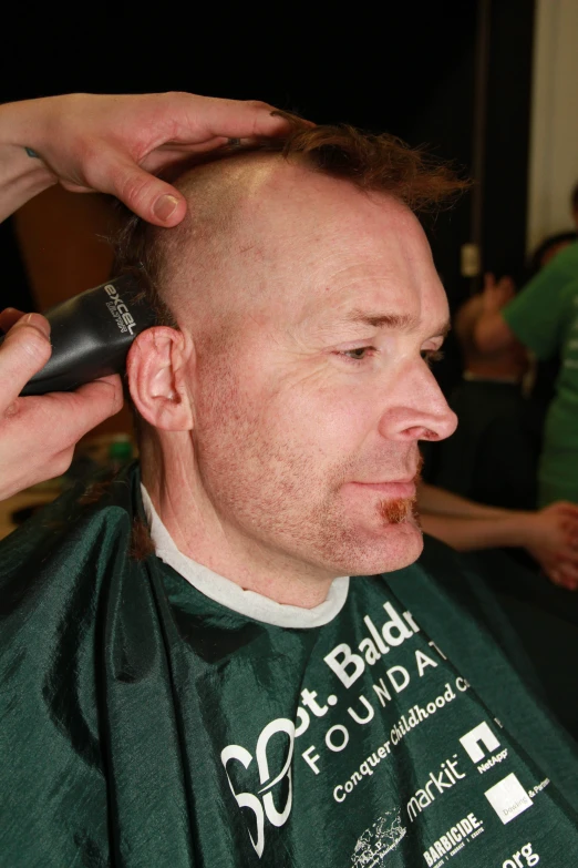 the man is getting his hair cut for the first time