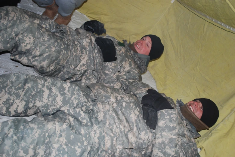 two soldiers are laying on top of one another