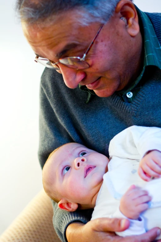 a man holds his baby as he looks at it