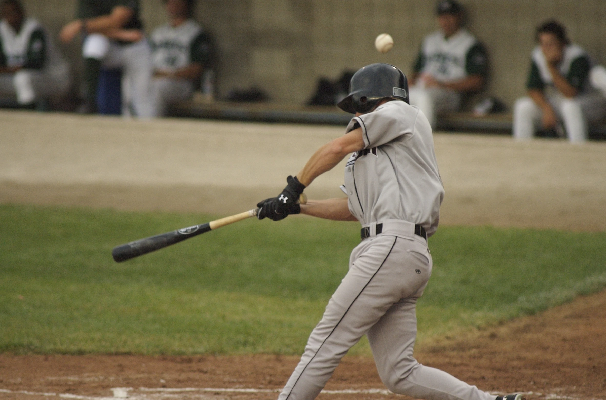 an adult baseball player swinging at a ball during a game