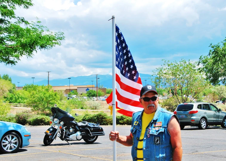 a guy in a vest holds a flag