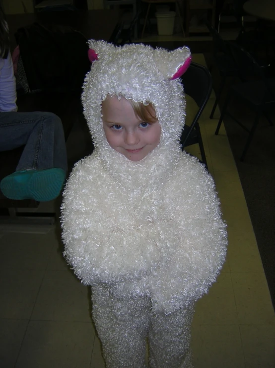 a child wearing a sheep costume standing in a room