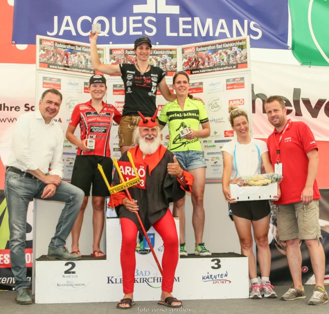 people on podium with man on horse and one woman holding a sign