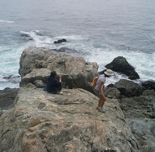 a couple sits on rocks with ocean view