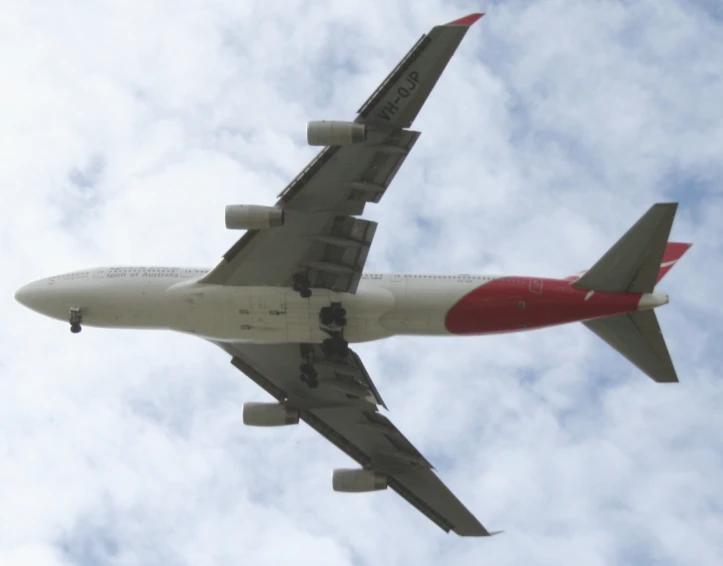 a red and white airplane flying in the air