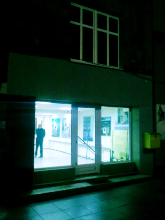 the man stands alone in front of the store door