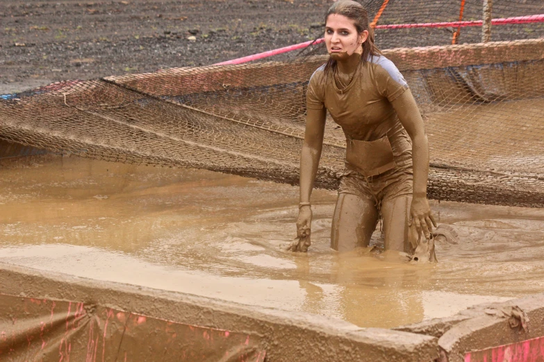 a woman is covered in mud on a muddy track