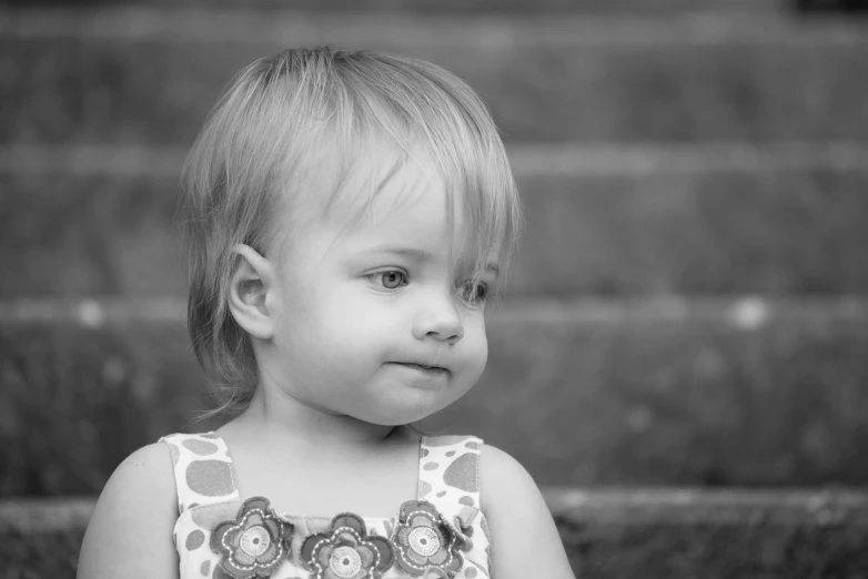 a little girl sitting on top of some steps