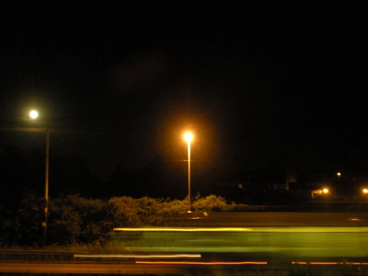 the street lights glow brightly on the dark night