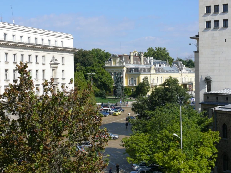 a city with lots of white buildings, cars and trees