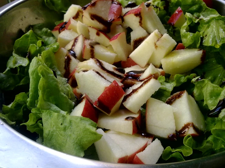 a metal bowl containing fruit on top of it