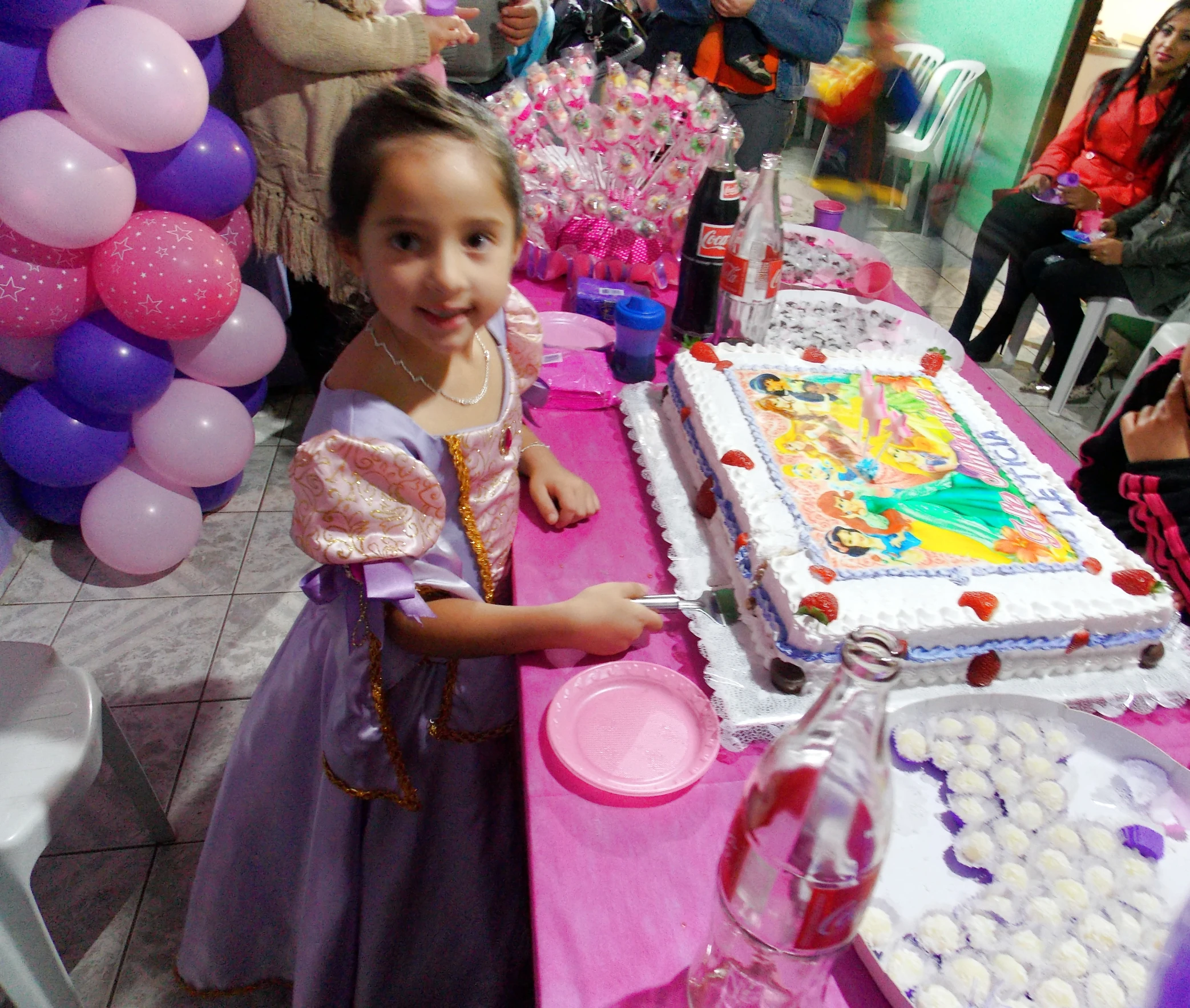 a  in costume stands in front of a table with many cakes