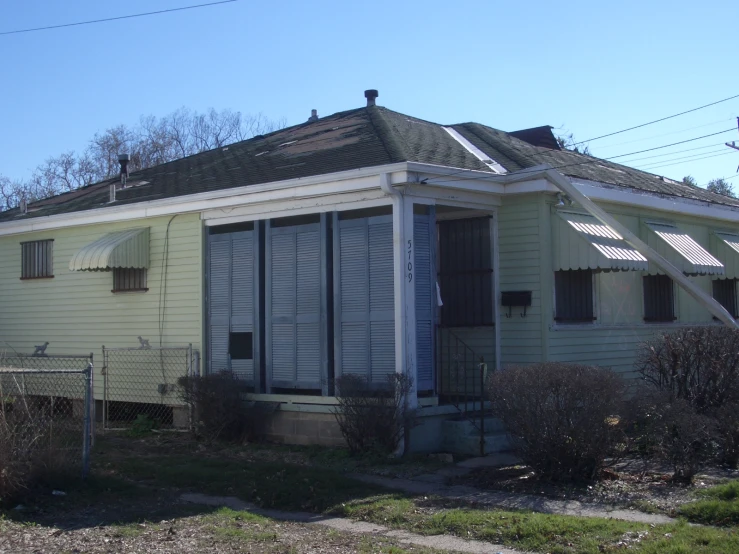 a house with a fence and bushes around it