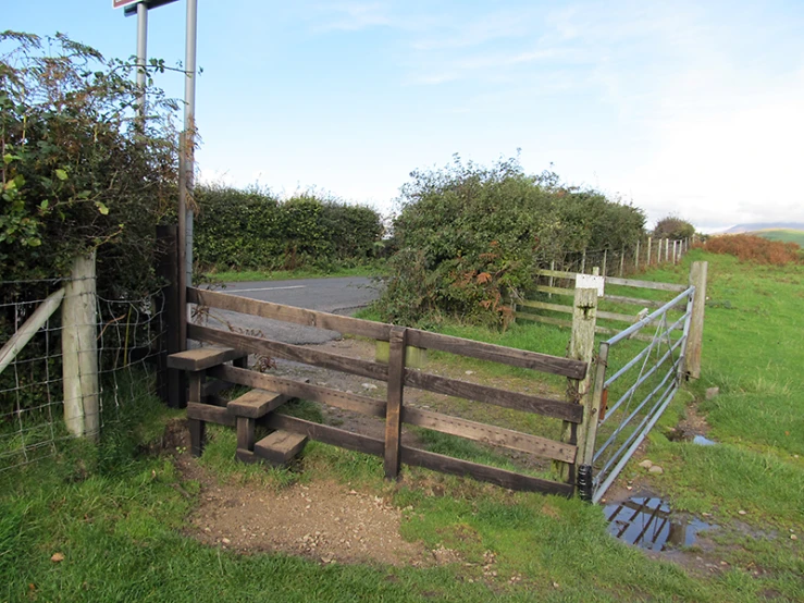 the gate to a fenced in pasture is opened