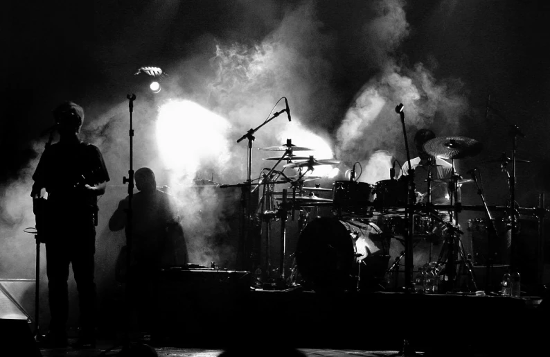 the band perform on stage with large smoke coming from behind them