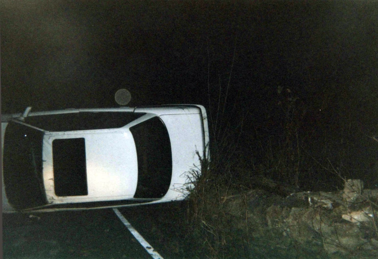 this is an old picture of an abandoned car in the night