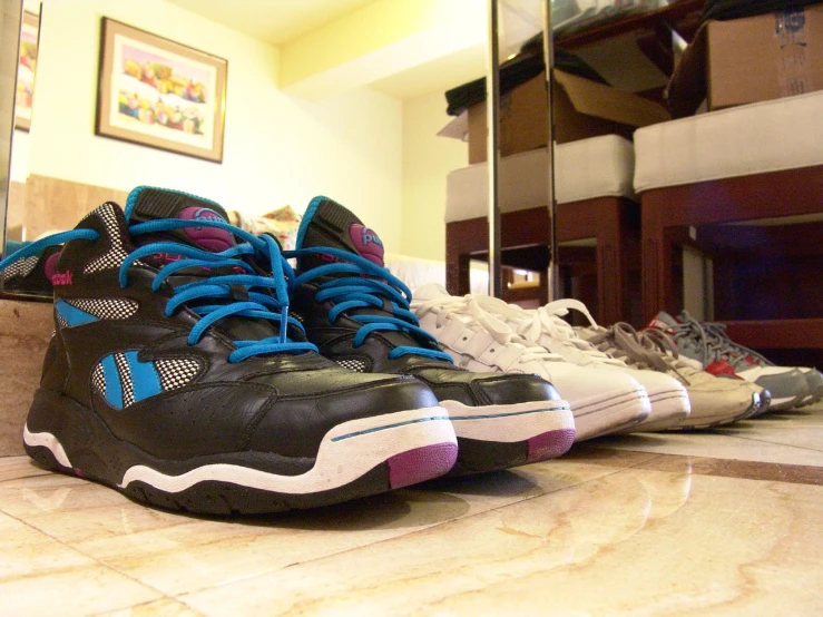 three pairs of sneakers lined up on the floor
