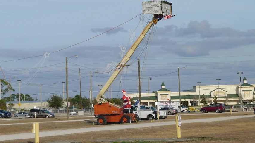 a worker is on the side of a truck repairing an electrical pole