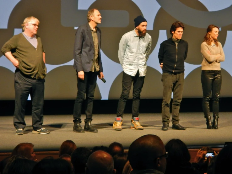 five people on stage with microphone in front of them