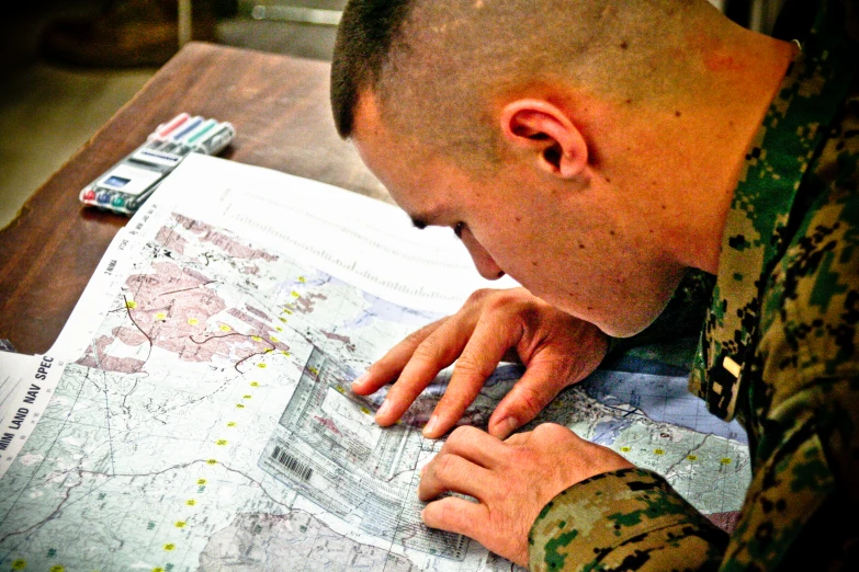 the soldier is studying an image on a map