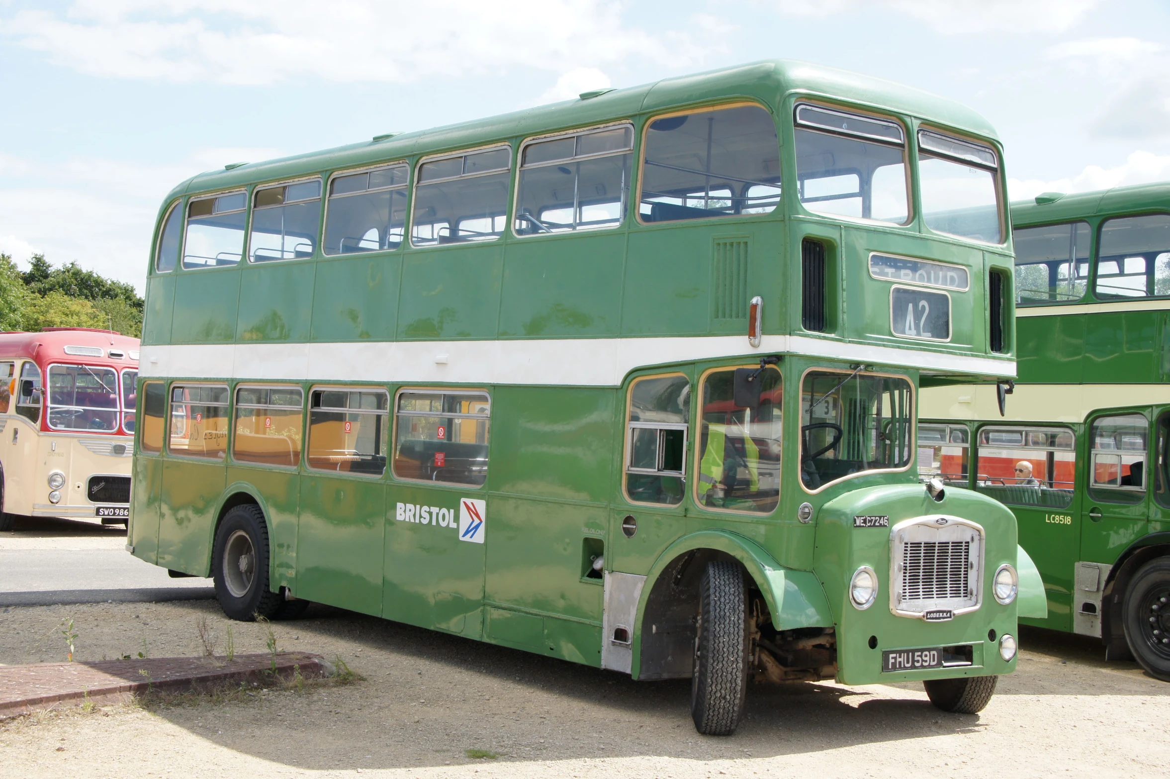 the double decker buses are parked in a lot