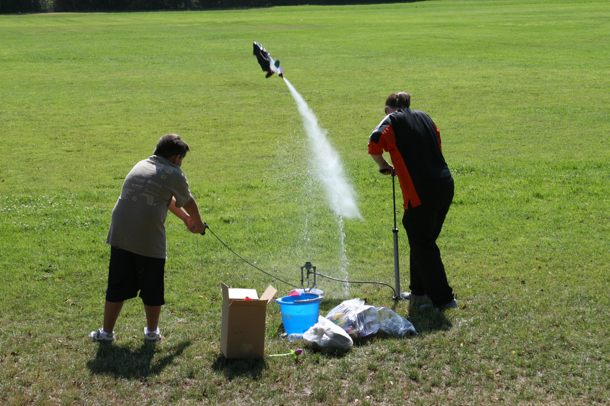 a couple of people spraying water on a field