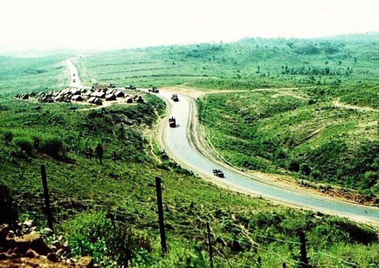 cars driving down a road with mountains in the background