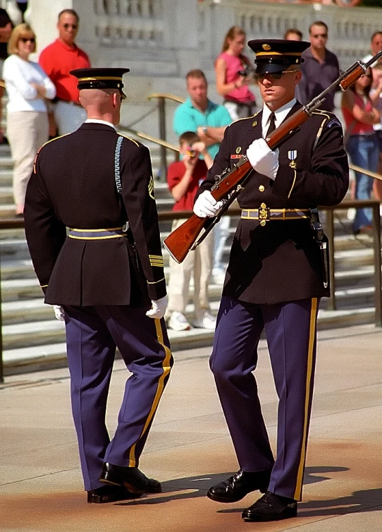 two men in military uniform holding guns standing on the street