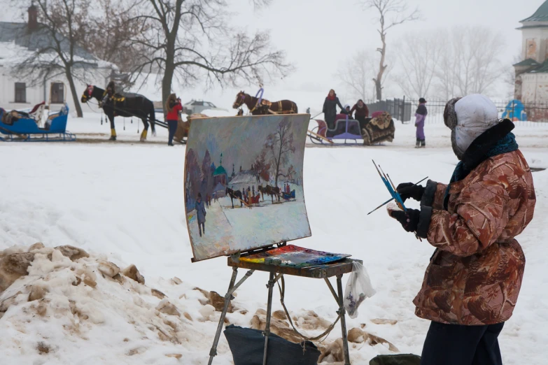 an artist in the snow holding his paintbrush, painting