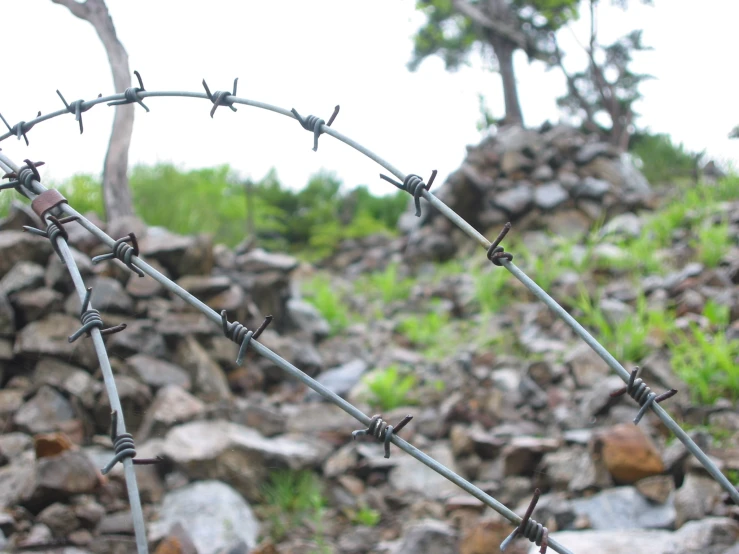 some barbed wire against a background of rocks