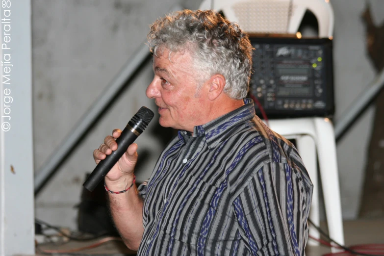 a man standing behind a microphone with long hair
