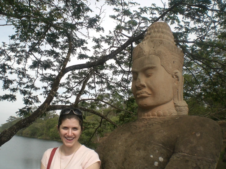 woman posing next to large statue of a woman