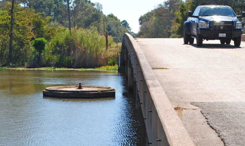 a vehicle drives over a small obstacle in the middle of the water