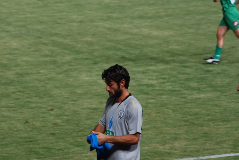 a man holding a glove while standing on a soccer field