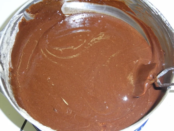 a bowl of chocolate batter is sitting on a table